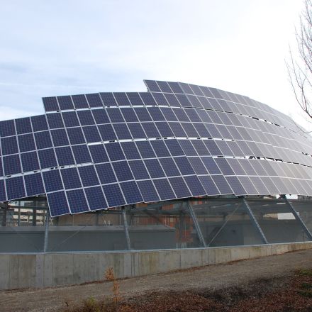 A large building featuring solar panels on its roof, showcasing sustainable energy solutions in an urban environment.