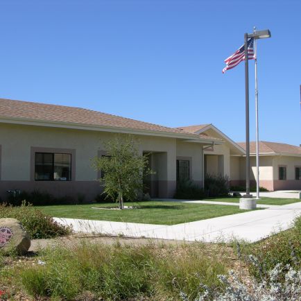 A large building featuring a prominent flagpole in front, showcasing its architectural design and national pride.